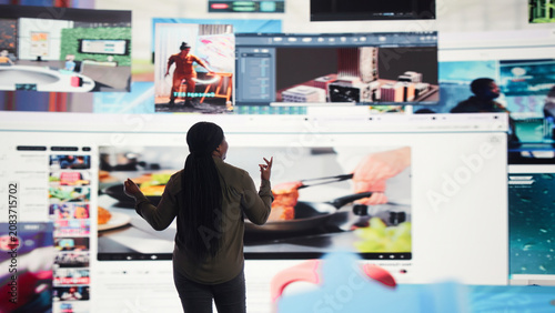 Foto Woman entertained by video content on multi-screen digital wall, concept of modern digital lifestyle