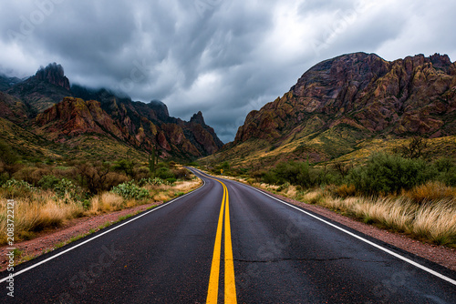 Asphalt highway winding through dramatic desert mountain landscape