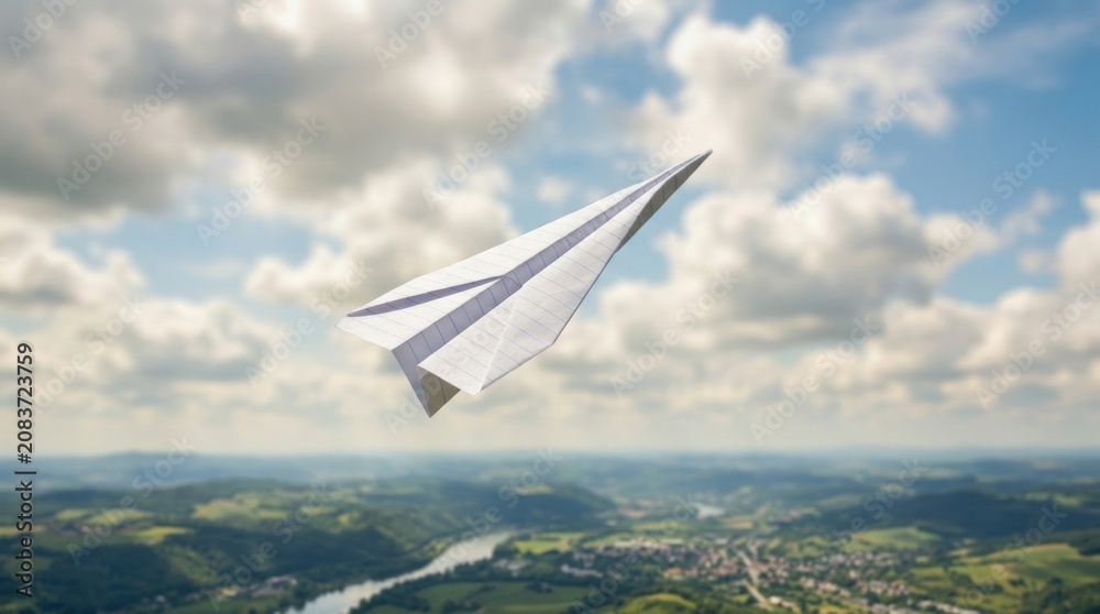 Fototapeta premium Paper airplane flying over rural landscape with soft clouds and distant river for playful travel poster or banner background design