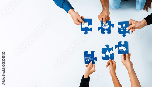 Tableau sur toile A dynamic scene showcasing diverse hands coming together to fit puzzle pieces, symbolizing collaboration, teamwork, and partnerships in a creative business setting