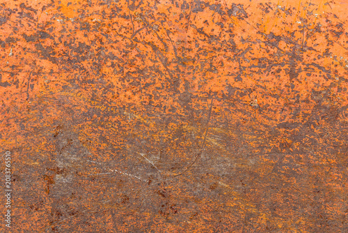 Close-up texture of weathered orange metal with rust and scratches, background, texture