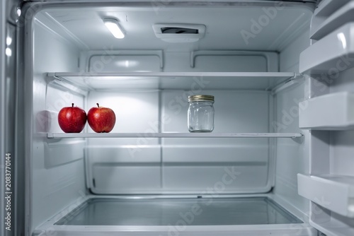 Sparse Refrigerator With Apples and Empty Glass Jar