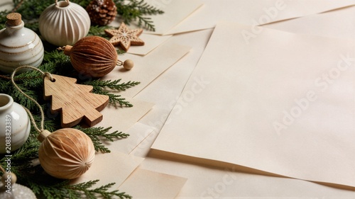 Muted neutral christmas ornaments with wooden decorations and blank paper sheets ideal for minimalist holiday branding stationery mockup and greeting card website