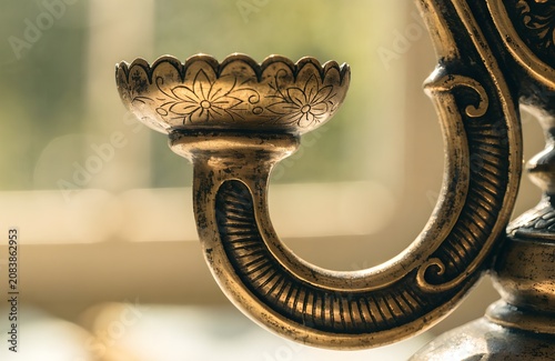 macro of antique brass candle holder worn patina fine engraved detail