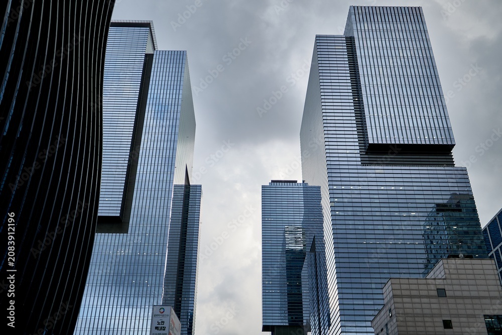 Fototapeta premium looking up at an angular modern building under cloudy sky