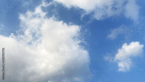 Foto Bright blue sky background filled with large fluffy clouds