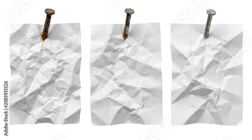 Three crumpled paper sheets with nails on top.