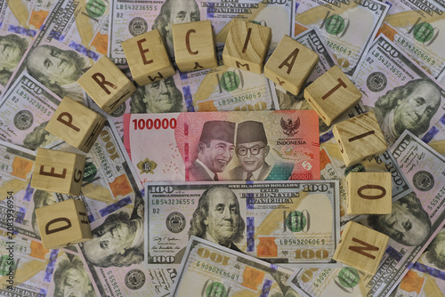 Illustration of depreciation Indonesian Rupiah banknote and US Dollar bills for currency exchange. depreciation money for finance concept with detail shot