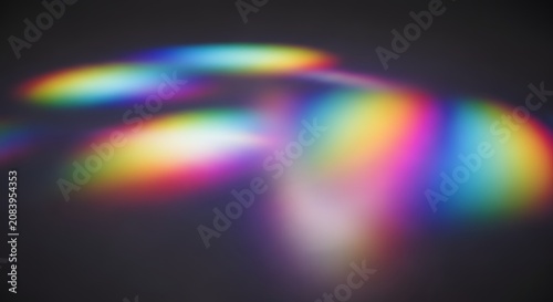 Abstract rainbow prism light refractions glowing on a dark grey surface with soft bokeh effect