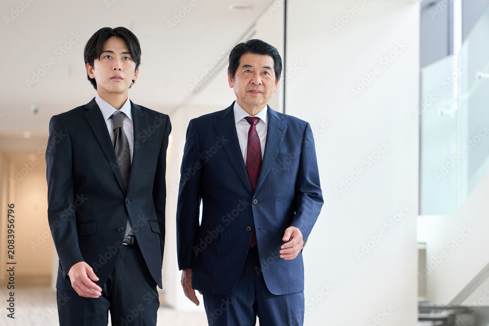 Fototapeta premium オフィス内を歩くアジア人ビジネスパーソン