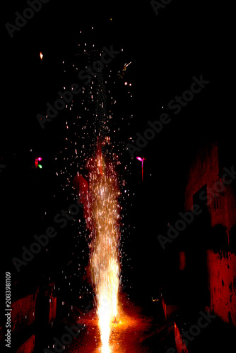 Firework Fountain Night – Vertical Stream of Orange Yellow Sparks with Glowing Flames and Festive Background Lights Concept