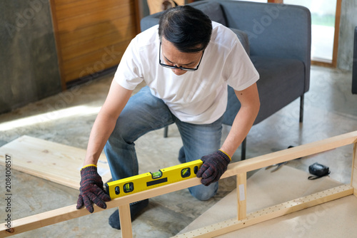 Carpenter wood level frame workshop construction tool measuring wooden structure during home renovation with focus
