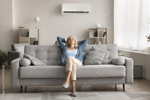 Peaceful, single, elder, on, pension, rest, on, soft, cozy, couch, at, modern, living, room, in, relaxed, pose., Calm, serene, older, age, lady, take, break, from, daily, routine, breath, fresh, clean
