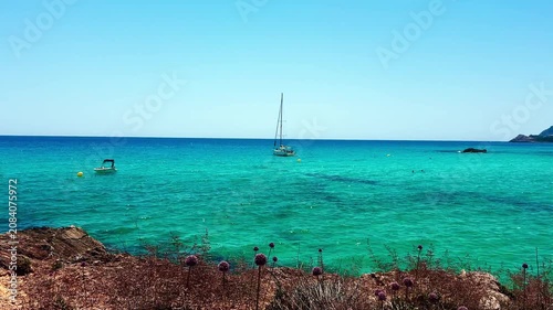 Crystal clear turquoise sea water and scenic rocky coast with sailing boats under a blue sky. summer vacation concept.