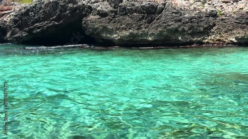 Crystal clear turquoise sea water and scenic rocky coast with sailing boats under a blue sky. summer vacation concept.