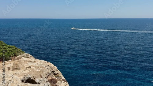 Crystal clear turquoise sea water and scenic rocky coast with sailing boats under a blue sky. summer vacation concept.