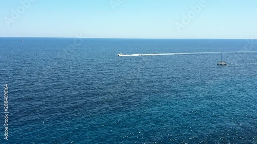 Crystal clear turquoise sea water and scenic rocky coast with sailing boats under a blue sky. summer vacation concept.