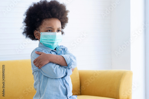 African boy wears a face mask for hygiene purposes. Prevention of respiratory infectious diseases in children. looking at someone