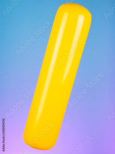 Close-up of an inflatable stick on a purple background, highlighting its simple and vibrant design. Perfect for fun and summertime play.