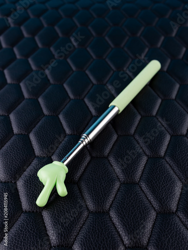 Close-up of a metallic pointer in the shape of a hand with the index finger on a black background