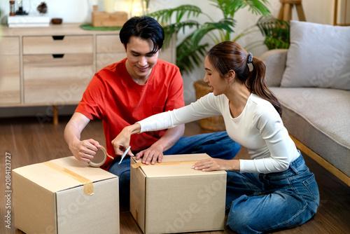 Woman And Man Pack Cardboard Box For Upcoming House Move