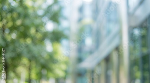 Abstract blurred background of a modern building and green park with bokeh.