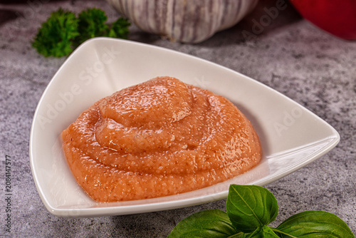 Photos Cod fish roe spread in white triangular dish with fresh basil and garlic backgro