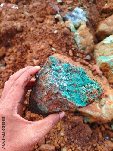 Fotografie Geologist holding natural unpolished saprolite nickel ore specimen, raw mineral resource for electric vehicle battery industry and metallurgy