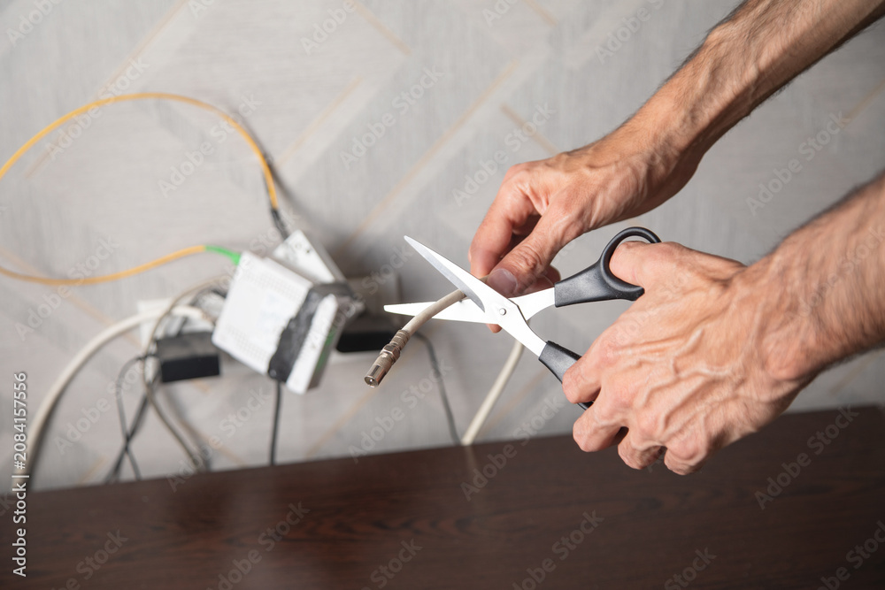 Fototapeta premium Caucasian man cutting internet cable with a scissors.