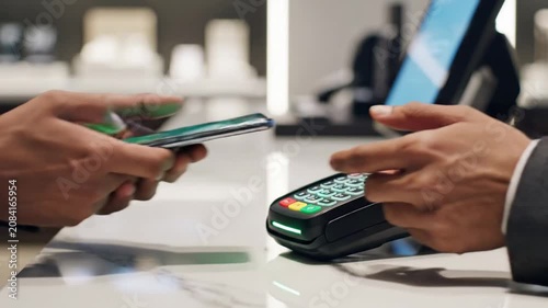Hands using smartphones for digital transaction at retail counter.