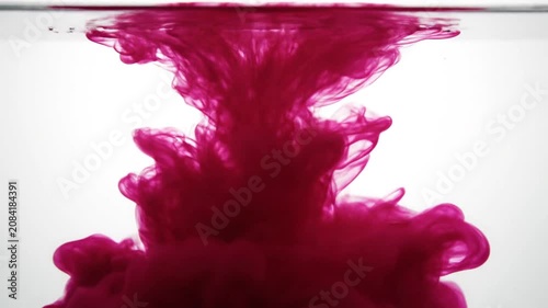 Large red ink cloud expanding underwater on white.
