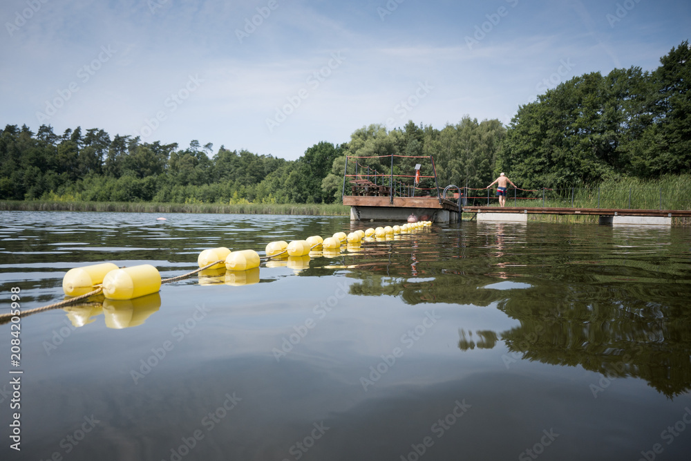 Obraz premium Buoys marking the area of ​​a supervised swimming zone. A lakeside swimming area in summer. 