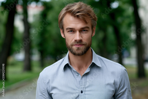 Man stands outdoors among trees in a city park