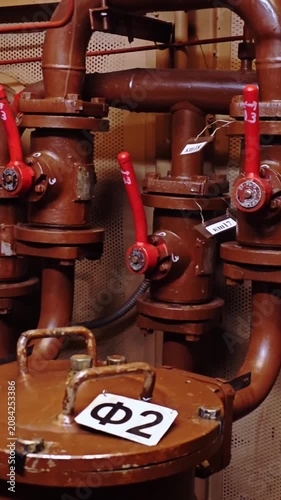 Dense pipe network with red handles and curved elbows, service perspective emphasizes junctions, tags and compact fittings in a busy mechanical room, maintenance team context implied