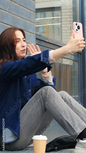 Female capturing cityscape photograph with precision. Girl taking picture of city reflection with wellcomposed framing. Caucasian woman adjusting her camera to photograph urban skyline properly