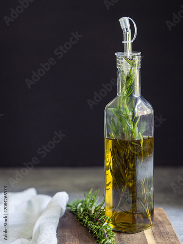 Schilderij op canvas Rosemary-infused extra virgin olive oil in a glass bottle