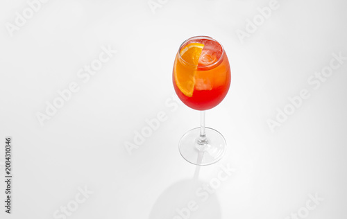 Refreshing Aperol Spritz Cocktail with Orange Slice and Ice in Wine Glass on White Background with Copy Space