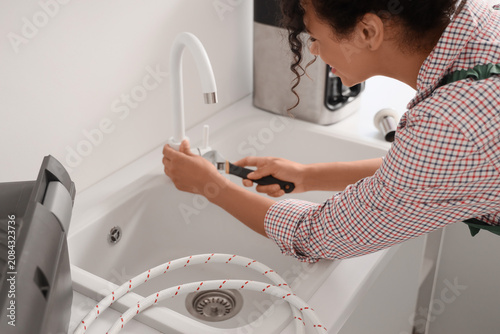 Female plumber fixing fauce...