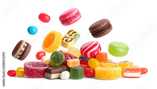 Pile of colorful assorted candies and macarons falling and scattered, sweet treats and confectionery, isolated on white
