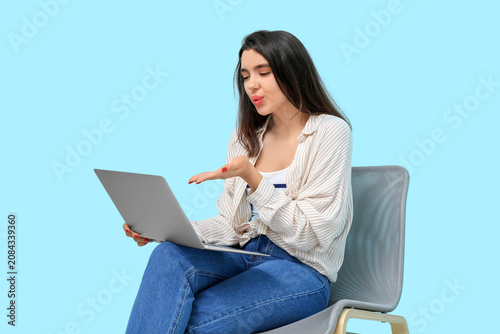 Young woman with laptop blo...