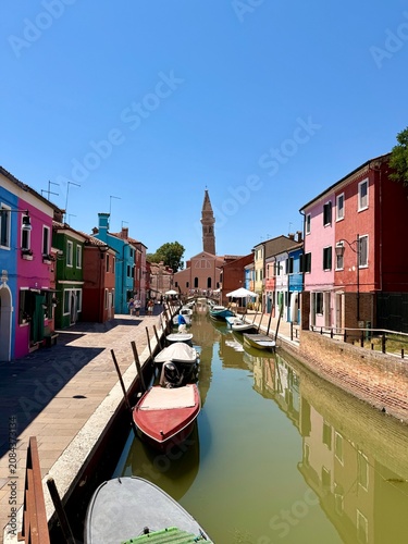 canal in Burano. Colorful houses and San Martino, the only church in Burano with a leaning bell tower