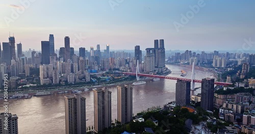 Aerial view of the city skyline and a bridge crossing the river at sunset in Chongqing, China