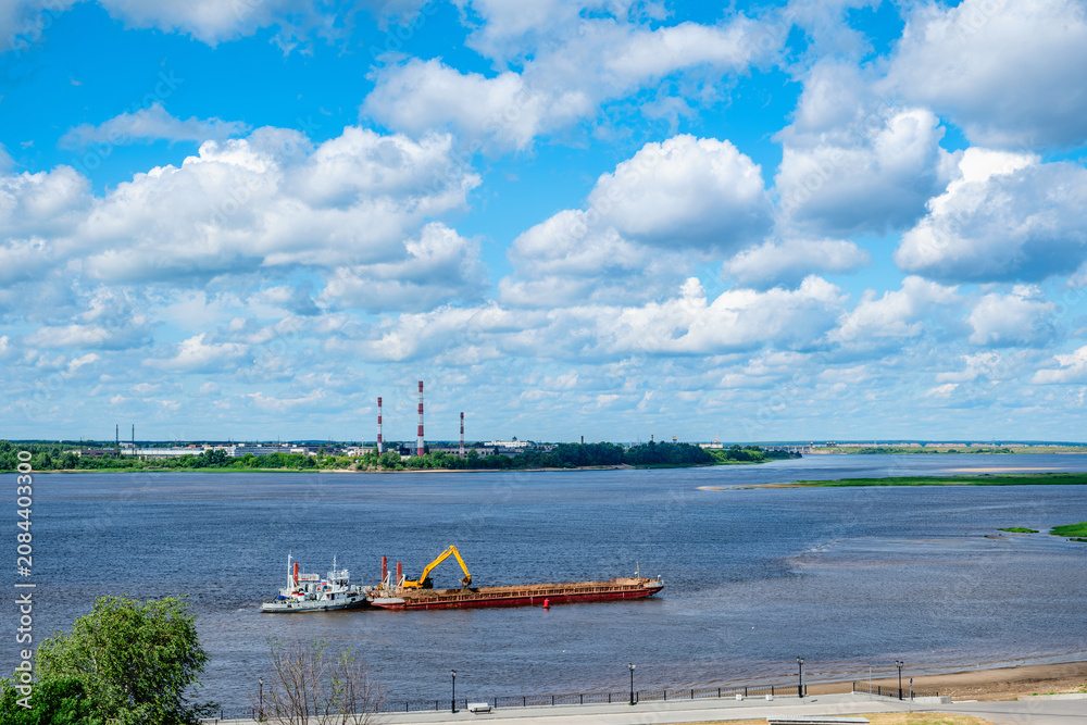 Fototapeta premium A barge with a crane is located on the river; the river is actively used for cargo transportation and commercial activities.
