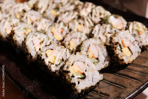 Stack of Japanese sushi maki roll in black plate. Served in Japanese bar restaurant