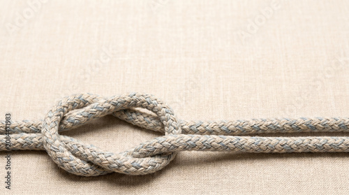 Textured rope knot on neutral background with minimalist style  