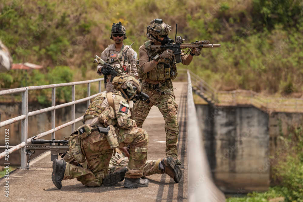 Fototapeta premium Soldiers conduct tactical training on a bridge during the day with focus on teamwork and coordination