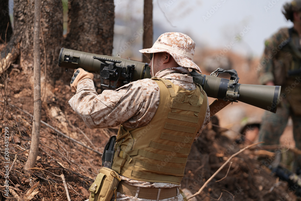 Fototapeta premium Soldier aiming a rocket launcher during military exercises in a forested area