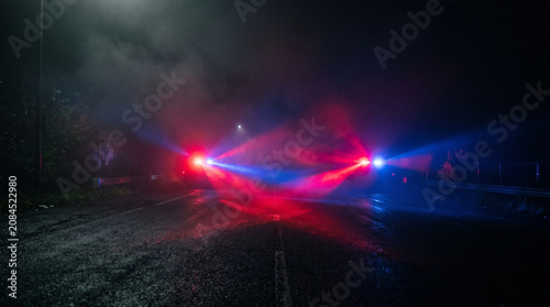 Emergency Vehicle Lights Flashing on Dark Foggy Road at Night