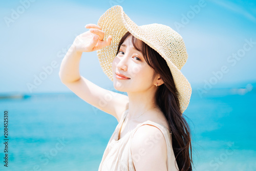 海と青空を背景にした若い女性