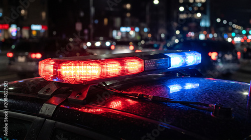 Police Emergency Light Bar Flashing Red and Blue on Patrol Car at Night